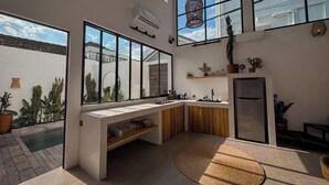 A modern kitchen with large windows, a built-in oven, and a refrigerator.