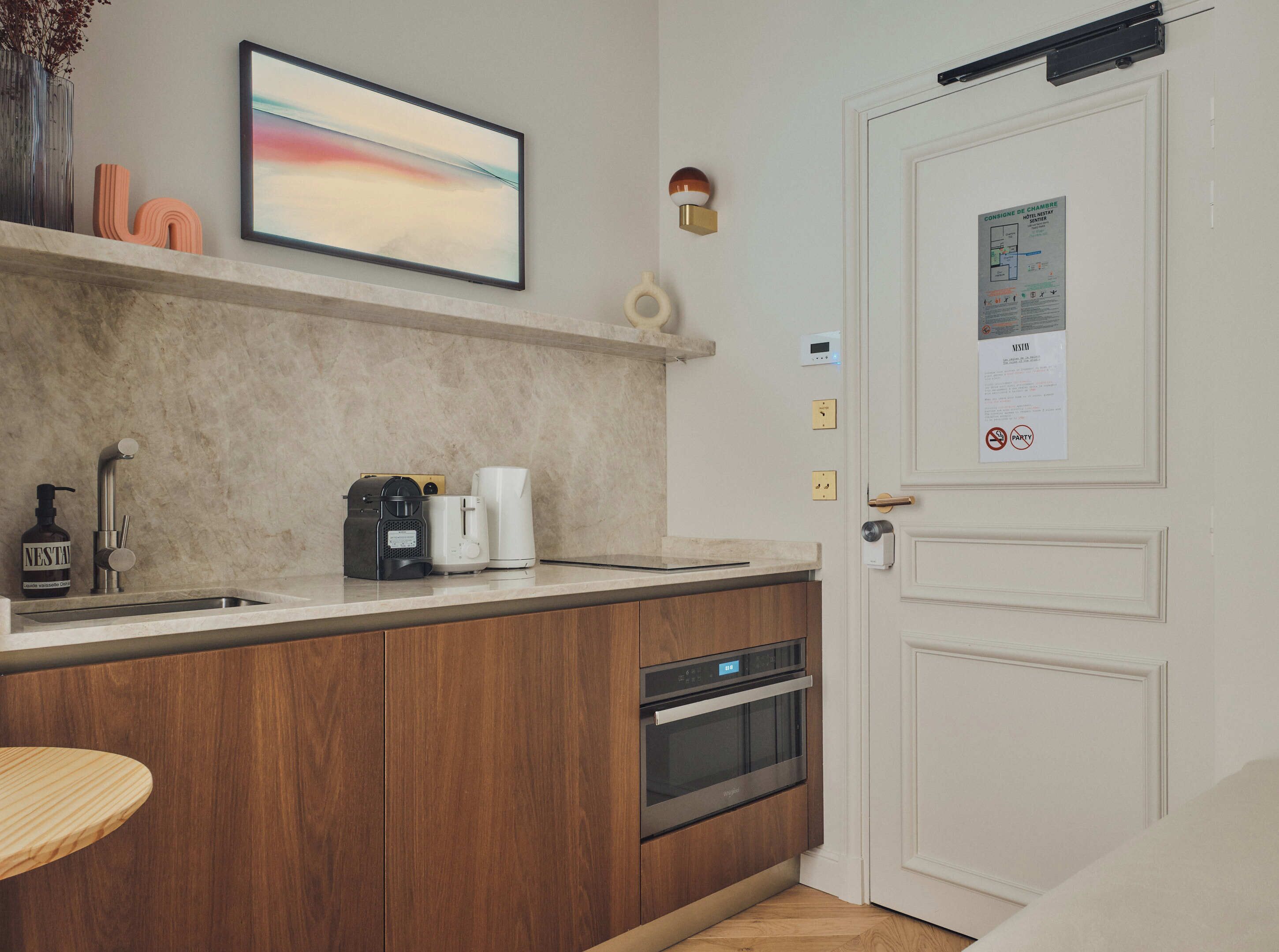 A modern kitchen with a built-in oven, a coffee maker, and a Nespresso machine.