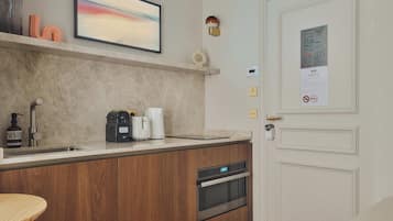 A modern kitchen with a built-in oven, a coffee maker, and a Nespresso machine.