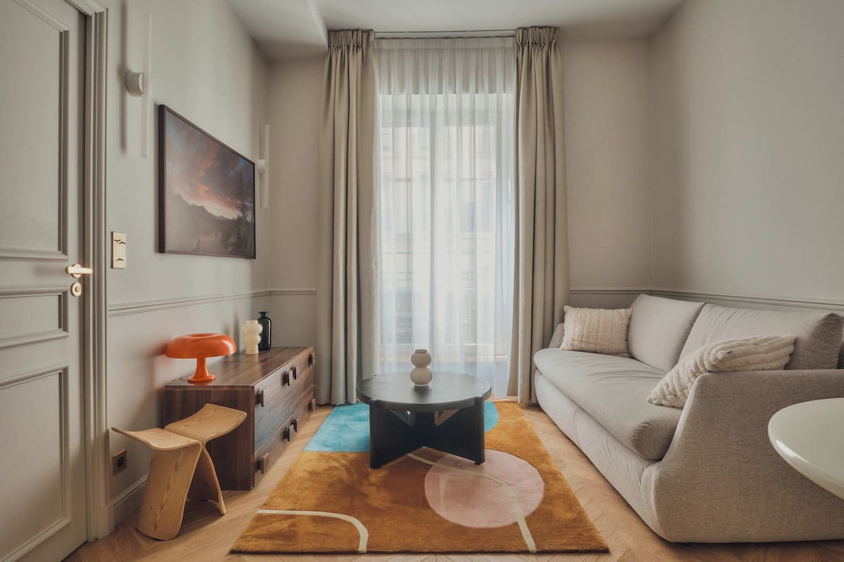 A modern living room with a sofa, a coffee table, a side table, and a painting on the wall.