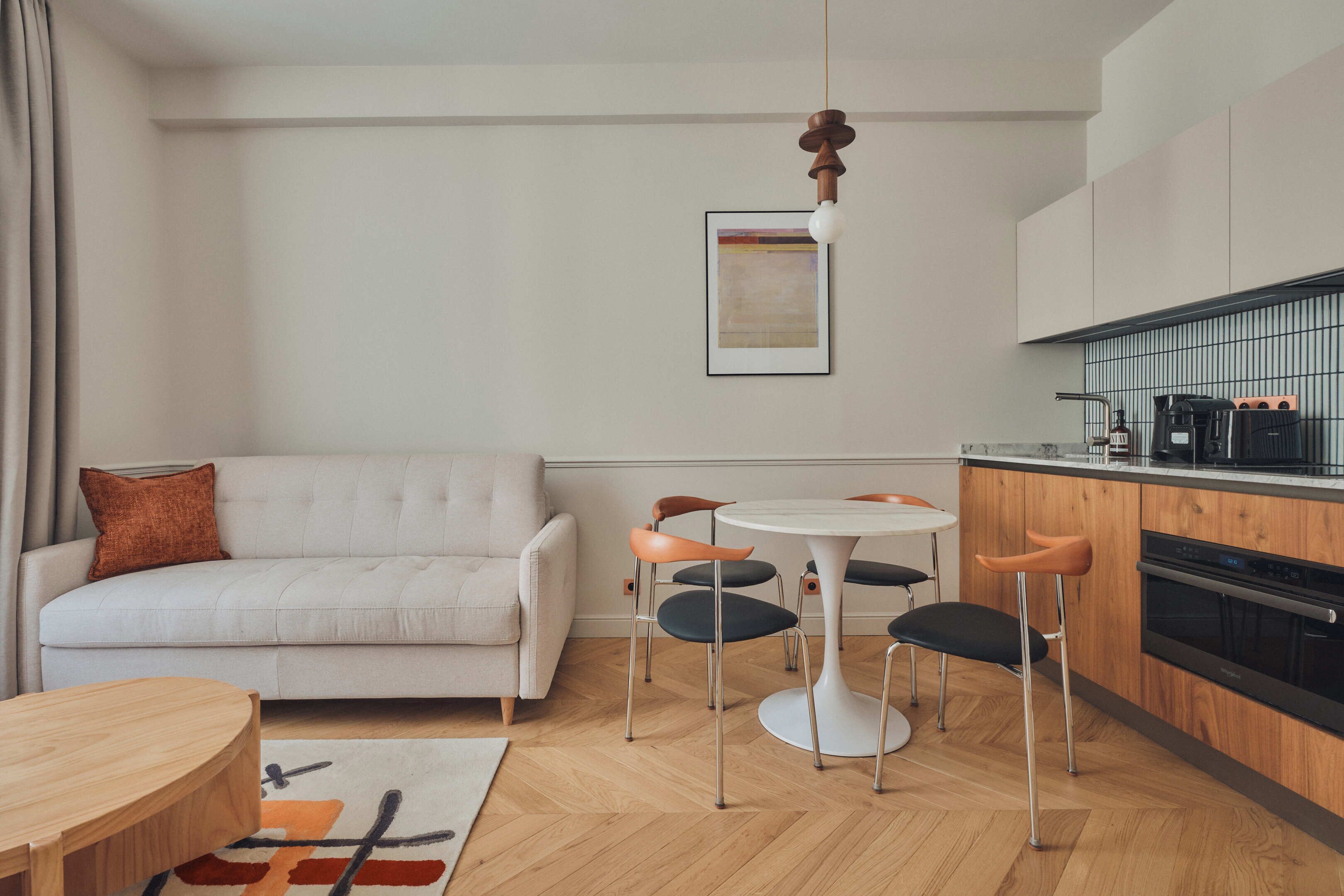 A modern living room with a sofa, a coffee table, and a dining area with chairs.