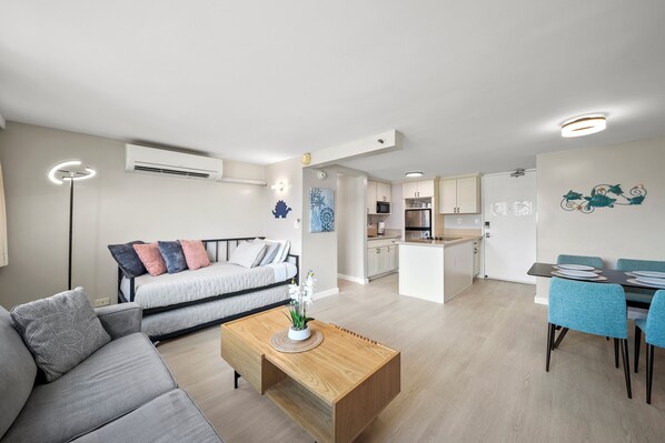 A modern apartment with a living room, dining area, and kitchen.