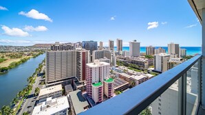 Un edificio alto con vistas a un paisaje urbano, incluyendo un río y una playa.