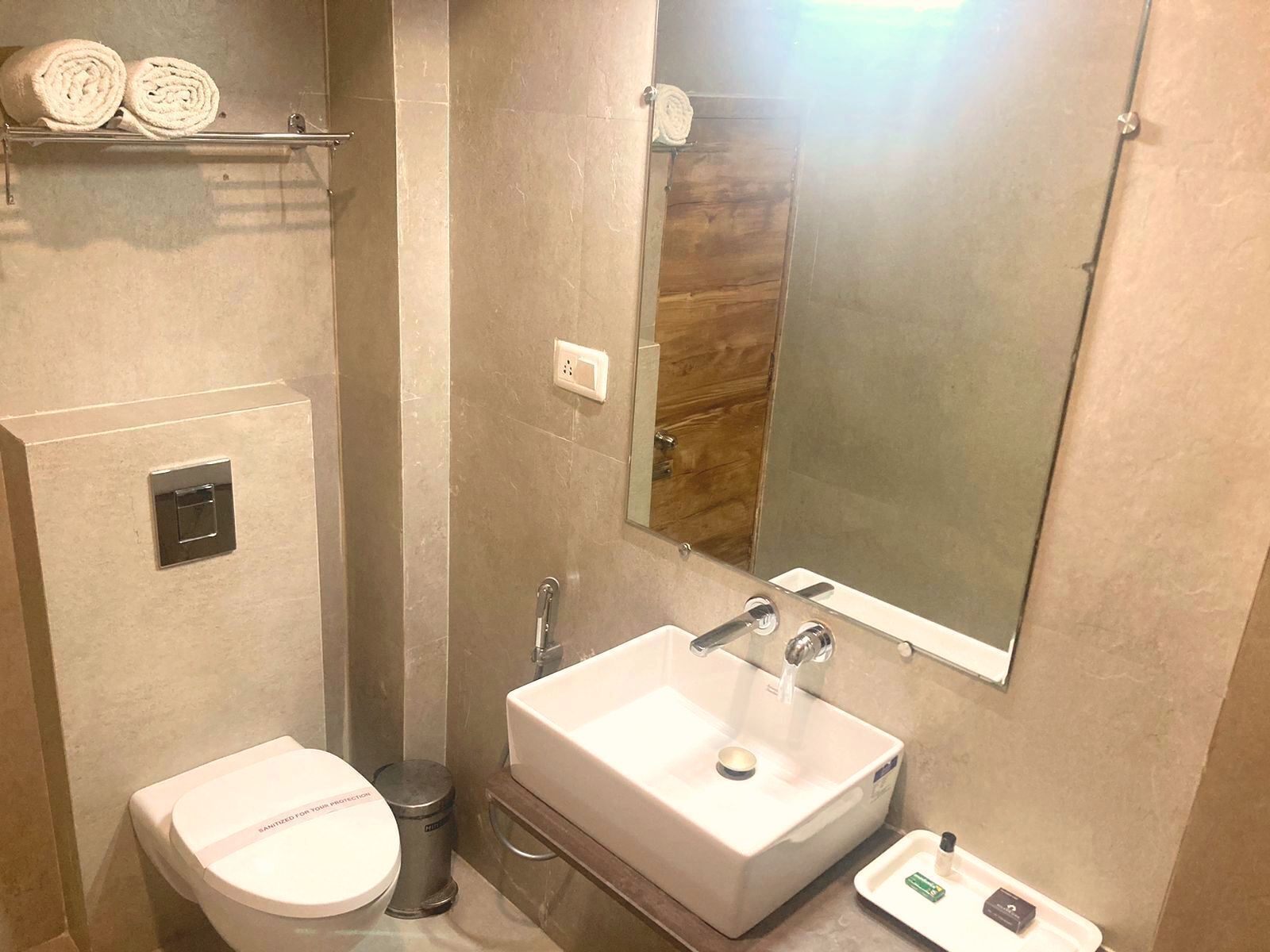 Un baño moderno con inodoro, lavamanos y espejo.