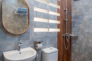 A modern bathroom with a sink, mirror, toilet, and shower. - Blok M Residence (South Jakarta)