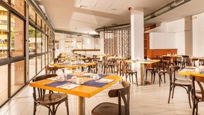 A spacious dining area with multiple tables and chairs, large windows, and a modern interior design. - Hotel Boutique Can Colom (Lloret de Mar)
