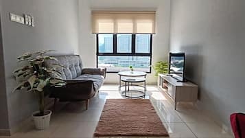 Departamento Deluxe, vista a la ciudad | Área de sala de estar | Televisión de pantalla plana