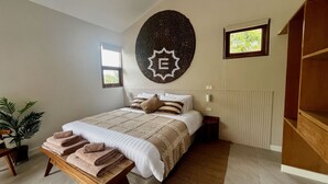 A bedroom with a bed, a wall decoration, a window, and a plant. - La Balinaise (Chaweng Noi)