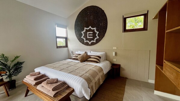 A bedroom with a bed, a wall decoration, a window, and a plant. - La Balinaise (Chaweng Noi)