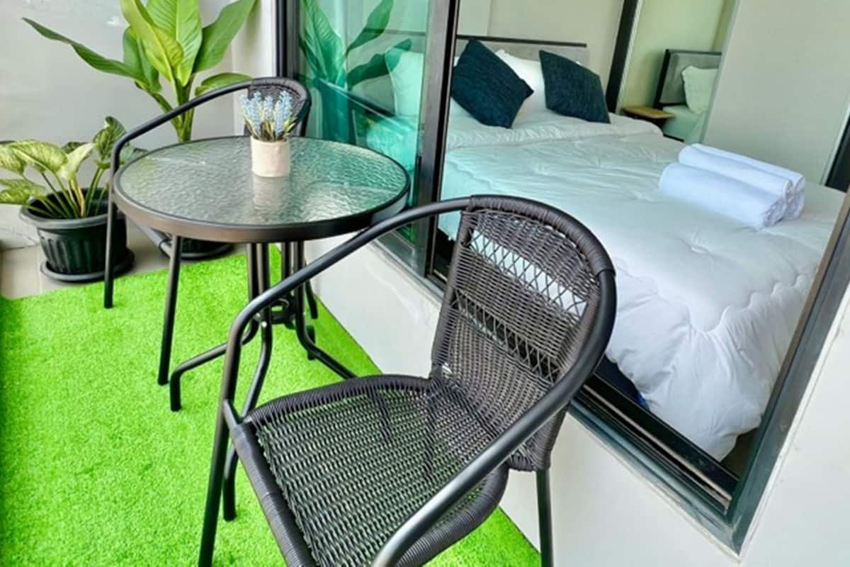 Ein kleiner Balkon mit einem Bett, einem Tisch und zwei Stühlen.