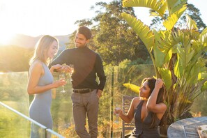 A terrace with a glass railing, a table, and chairs. - Ralphie’s Villa - 2 bed 2 bath with Valley Views (Kangaroo Valley)