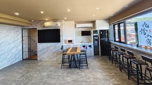 A modern kitchen with a central island, bar stools, and a large window.