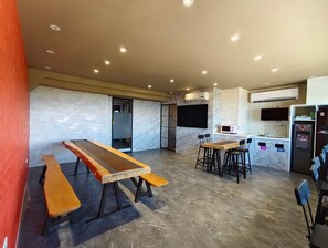 Relax in this spacious room with a kitchenette, featuring a microwave, refrigerator, and sink, and enjoy seating at two tables with benches.