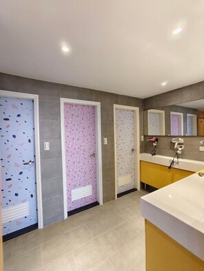 Contemporary bathroom with a unique tile design, large mirror, and clean floor.
