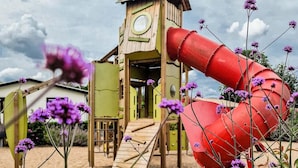 A wooden play structure with a slide and a small tower. - Modern Chalet With Dishwasher (Nieuwerkerk aan den IJssel)