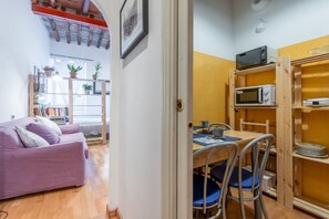 A compact living space with a kitchenette, a dining area, and a sofa.