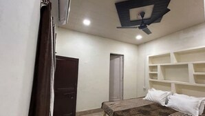 Un dormitorio con cama, ventilador de techo y estantería empotrada.