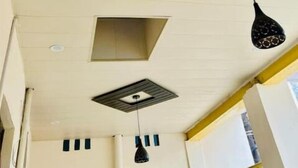 Techo con iluminación empotrada, un respiradero cuadrado y lámparas colgantes.
