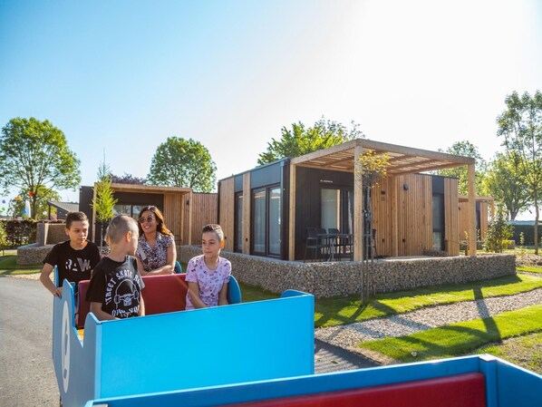 A modern building with a covered outdoor area, stone walls, and a paved pathway. - Nice Chalet With Dishwasher, Maastricht at 9 km (Berg en Terblijt)