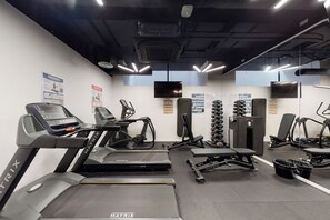 Ein Fitnessstudio mit Laufbändern, Crosstrainern und Gewichten.