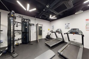 A gym with treadmills, a squat rack, and weightlifting equipment. - Chapter Westminster - Campus Accommodation (London)