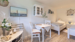 Une chambre confortable avec un lit, une table de chevet et un bureau avec une chaise.