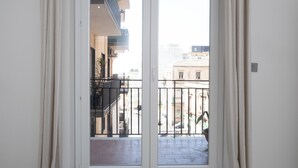 A view from a balcony with a metal railing, looking out onto a street with buildings and parked cars. - Adelina House | Quiet and Central Flat near University and Subway (Catania)