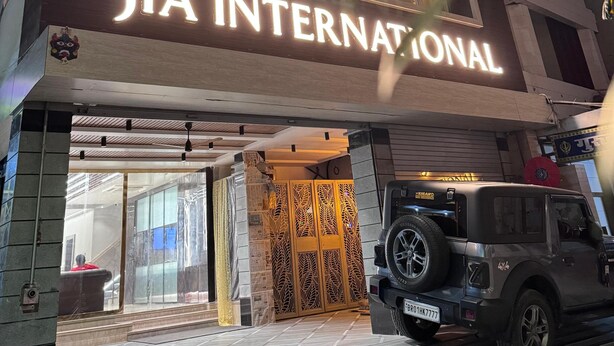A hotel entrance with a sign reading "JIA INTERNATIONAL" and a parked SUV. - HOTEL JIA INTERNATIONAL (Patna)