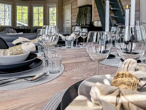 A dining table set with clear glassware, plates, and cutlery, indicating a formal dining arrangement. - Villa taikavuosseli by Interhome (Kuusamo)