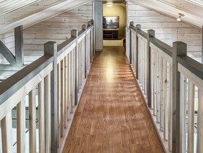 Un intérieur en bois avec un couloir central menant à une pièce équipée d’un téléviseur.