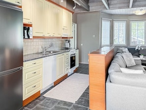 A modern kitchen with a built-in oven, a coffee maker, and a sink. - Villa taikavuosseli by Interhome (Kuusamo)