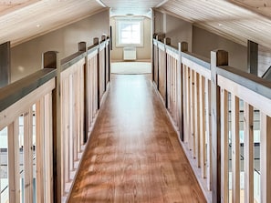 A long, narrow hallway with wooden railings on both sides and a wooden floor. - Villa taikavuosseli by Interhome (Kuusamo)
