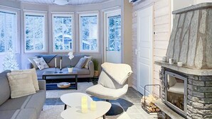 A cozy living room with a fireplace, a sofa, a coffee table, and a chair.