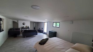 A spacious bedroom with a large bed, a sofa, and a dresser.