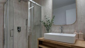 A modern bathroom with a glass-enclosed shower, a wooden vanity with a large sink, and a mirror above the vanity. - Stylishly renovated, king bed, 120m from telecabin (Les Houches)