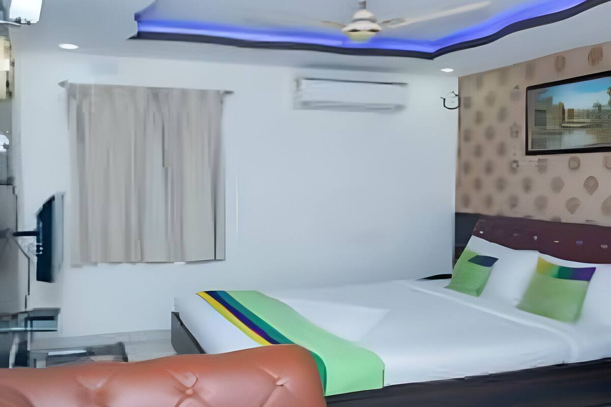 A bedroom with a bed, a ceiling fan, a window with curtains, and a wall-mounted air conditioner.