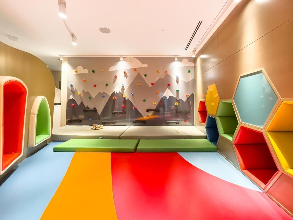 A play area with colorful seating and climbing walls.