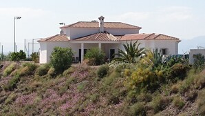 A white building with a tiled roof, surrounded by vegetation and a hilly landscape. - Mediterranean View Villa (Arenas)