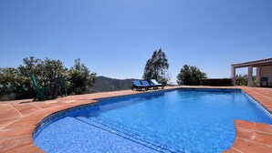 A swimming pool with blue tiles, two lounge chairs, and a pergola. - Mediterranean View Villa (Arenas)