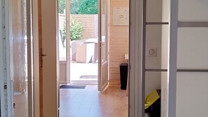 A hallway with a wooden floor leading to an open door.