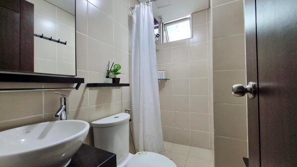 A bathroom with a sink, toilet, and shower curtain.