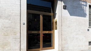 A building entrance with a glass door and a number plate. - notaMi - Rainbow Home - CityLife (Milan)