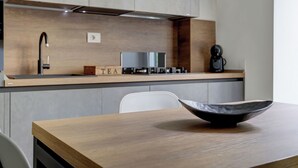 Eine moderne Küche mit einer Holzausziehtischplatte, einer schwarzen Schüssel auf dem Tisch und einer Kaffeemaschine.