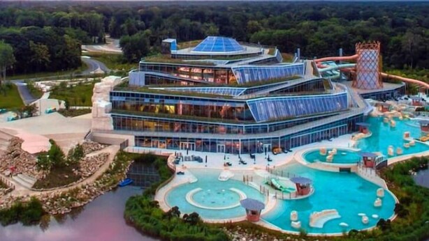 A modern hotel with multiple swimming pools, a water park, and a large building with a unique architectural design. - Disney cocooning 5 minutes from the Park (Coupvray)