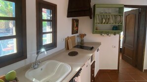 Een keuken met een wit aanrecht, een spoelbak en een raam met uitzicht op buiten.
