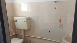 Un baño pequeño con azulejos, un inodoro, un lavabo y una zona de ducha.