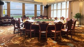 A formal dining room with a large chandelier, round table, and multiple chairs. - HALCYONBOWER INTERNATIONAL HOTEL (Quanzhou)