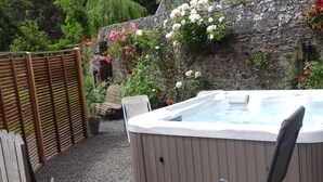 A hot tub with a wooden deck, surrounded by a wooden fence and potted plants. - Charming Country House with Private Spa, Fireplace, and Family-Friendly Amenities (Bricqueville-la-Blouette)