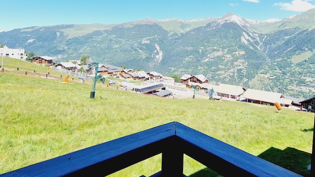 A mountain village with traditional wooden houses, a ski lift, and a clear view of the surrounding mountains. - Charming 2-room apartment at the foot of the slopes, south/west exposure, Plagne Montalbert (La Plagne Montalbert)