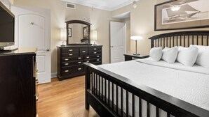 Un dormitorio con cama, cómoda y ventilador de techo.